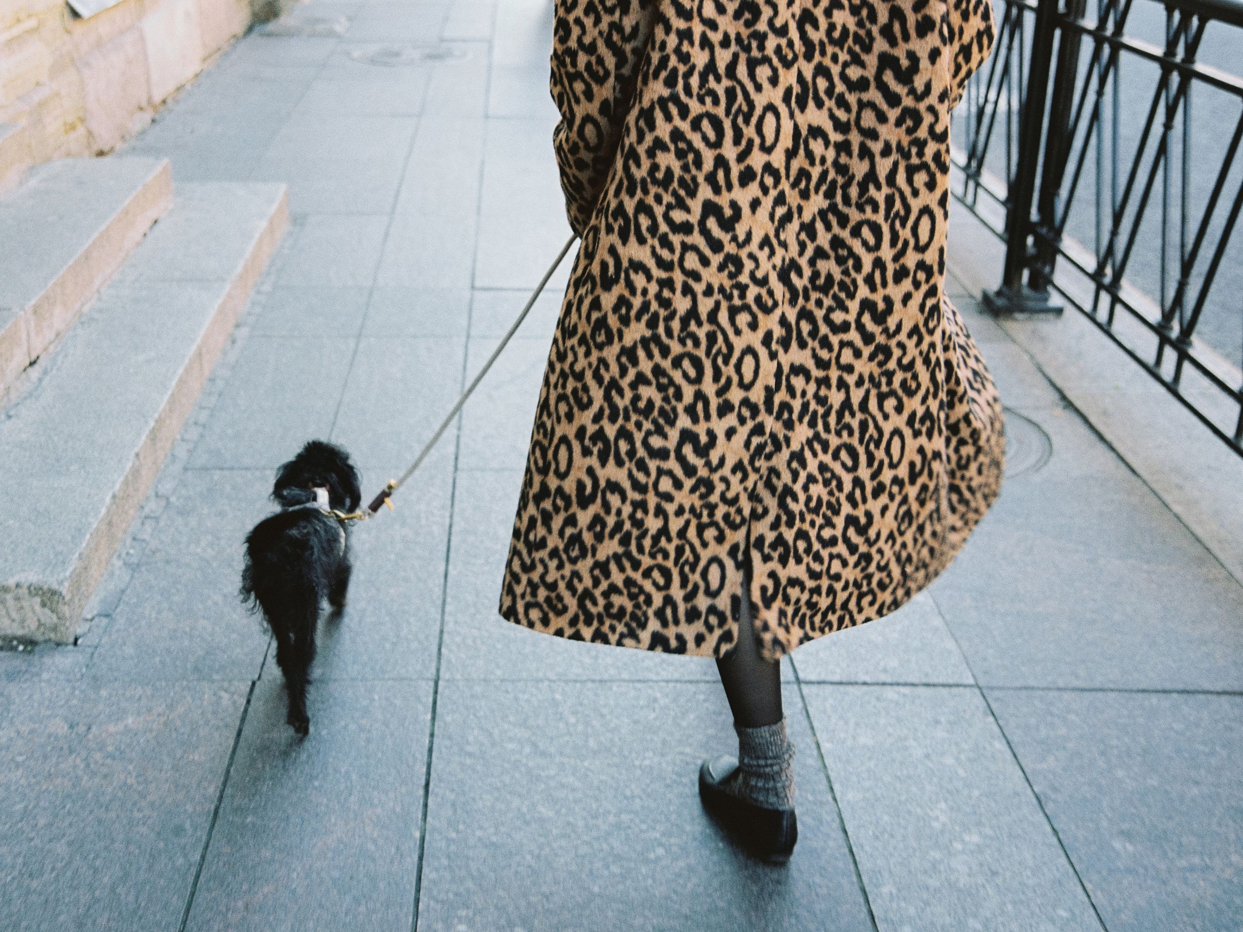 woman in long coat walking her dog